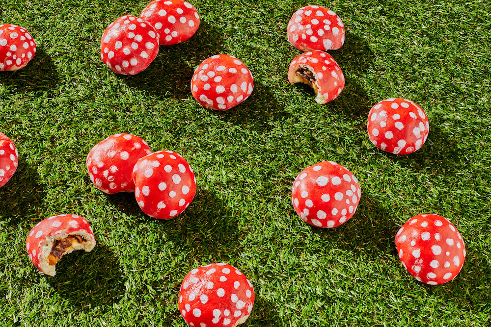 mini mushroom bao, red and white polka dots, on a bed of grass